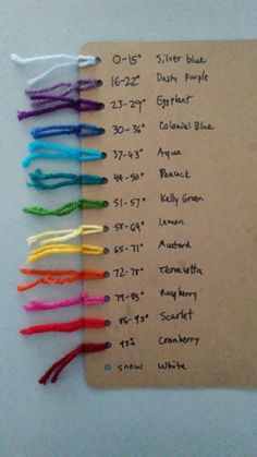 several colored crochet hooks are attached to a piece of brown paper with writing on it