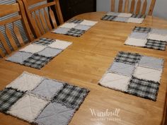 the table is set with four placemats on top of it, and there are wooden chairs