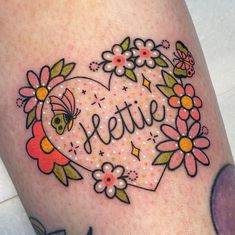 a woman's thigh with flowers and a bee on it that says jellie