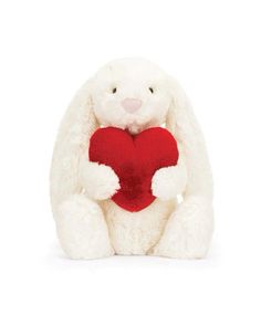 a white stuffed rabbit holding a red heart