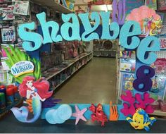 a mirror with the word shashie on it in front of a store filled with toys