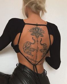 the back of a woman's body with tattoos on her upper and lower back