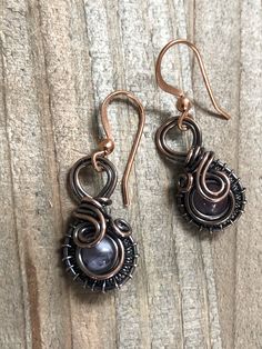 two pairs of earrings sitting on top of a wooden table