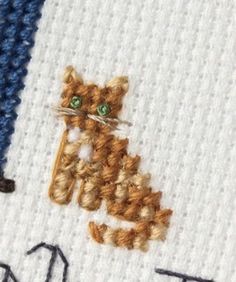 a close up of a cross stitch on a piece of cloth