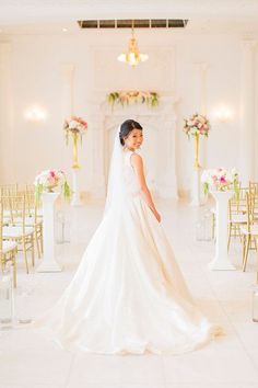 a woman in a wedding dress standing next to chairs