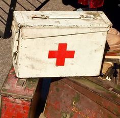 an old red cross box sitting on top of two trunks