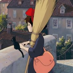 a woman holding onto a broom while standing on top of a building