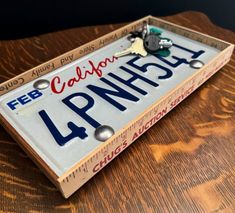 This State of California license plate "catch-all" tray will look great in any mudroom, office or bedroom to hold keys, sunglasses or wallets.  Unique, one of a kind gift. Handmade.  Each license plate is bolted to a piece of wood and surrounded by wooden yardsticks. Measurements:  12 inches in length 6 inches in width 1 1/2 inches in height. License Plate Diy Projects, Projects For Men, Repurposed License Plates Ideas, License Plate Craft Ideas, License Plate Tray, Cool License Plates Ideas, Wooden Car Accessories, Repurpose Old License Plates