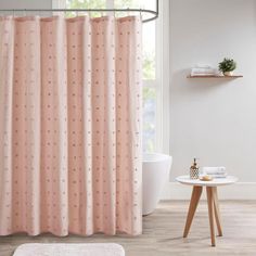 a bathroom with a pink shower curtain next to a white bath tub