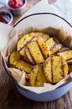 a bowl filled with fried potatoes on top of a wooden table