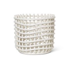 a white basket that is sitting on the ground