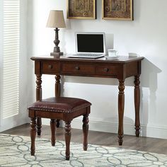 a wooden desk with a laptop on top of it and a chair in front of it