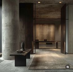 an empty room with two benches and a sculpture in the center, surrounded by concrete columns