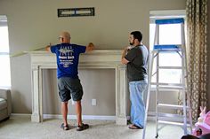 two men working on a fireplace in a living room