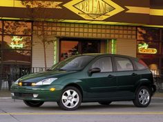 a green car parked in front of a restaurant