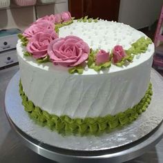 a white cake with pink and green flowers on it