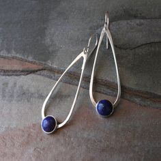 Lapis Lazuli teardrop dangle earrings. 8mm deep blue lapis set in sterling silver on handmade sterling silver teardrops. The teardrops swing from solid sterling silver ear wires. These earrings are 2 1/4 inches long including the ear wires. 5/8 inches at the widest part of the teardrop. For more Pierced Teardrop Pendant Jewelry For Gift, Modern Adjustable Drop Jewelry, Elegant Adjustable Nickel-free Teardrop Earrings, Modern Drop Matching Earrings Jewelry, Modern Nickel-free Drop Jewelry, Oval Hypoallergenic Teardrop Earrings As Gift, Hypoallergenic Oval Teardrop Earrings For Gifts, Nickel-free Teardrop Pendant Jewelry For Everyday Wear, Modern Oval Blue Earrings