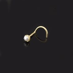 a gold nose ring with a single pearl