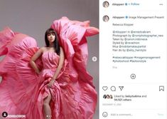 a woman in a pink dress standing on top of a bed