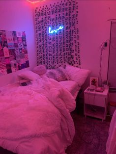 a room with two beds and a neon sign on the wall above them that says love