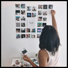 a woman is looking at photos on the wall