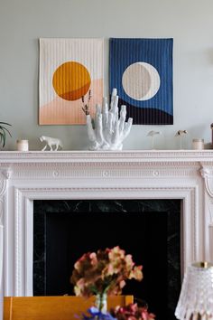 a fireplace with two paintings on the mantle