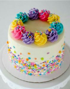 a white cake with colorful frosting and sprinkles