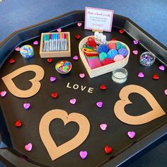 there is a tray that has some crafting supplies on it and the words love spelled out in large letters