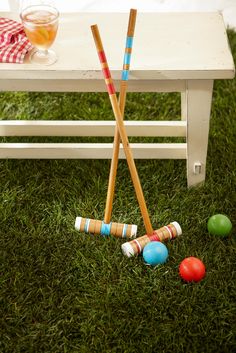 some croquets are laying on the grass next to a table with drinks