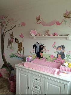 a baby's room decorated in pink and white with animals on the wall, crib