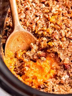 a wooden spoon in a crock pot filled with food