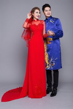 the man and woman are dressed up in traditional chinese garb, standing next to each other