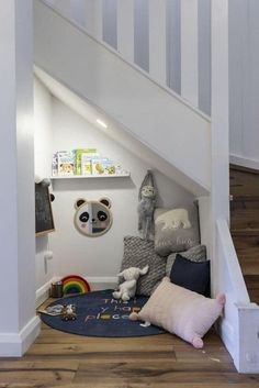 there are stuffed animals under the stairs in this child's playroom with toys