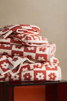 towels stacked on top of each other in red and white patterns, with one folded up to the side