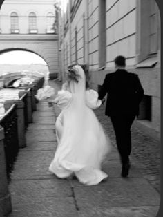 the bride and groom are walking down the street