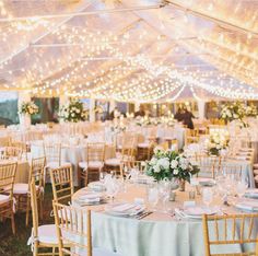 an outdoor tent with tables and chairs set up for a formal dinner or reception party