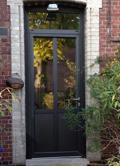 a black front door with glass and brick