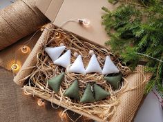 four small white and green ornaments in a box