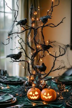 a table topped with two pumpkins and birds sitting on top of it's branches