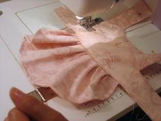 someone is using a sewing machine to sew something on the fabric with pink material