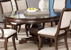 a dining room table with chairs and a bowl of lemons on the top of it