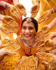 a woman is surrounded by hands covered in food