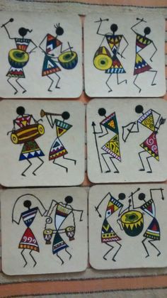 four coasters with different designs on them sitting on a table next to a brick wall