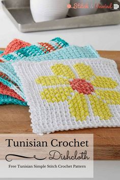 four crocheted coasters sitting on top of a cutting board next to a cup