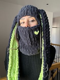 a woman with dreadlocks and a knitted beard wearing a green, black and grey scarf