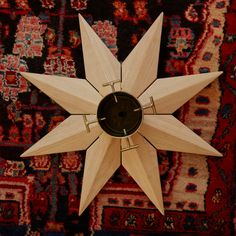 a wooden star clock sitting on top of a rug