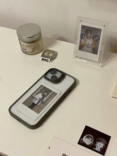 an iphone case sitting on top of a table next to some pictures and other items