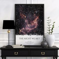 the night we met poster is displayed on a table next to two vases and a lamp