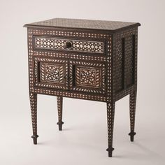 Precisely inlaid mother of pearl in a melange of traditional Rajasthani patterns gives the Bhawana nightstand loads of charm. The nightstand sits upon delicately tapered legs with spade foot detail. One drawer and double bottom doors provide good storage. Dimensions Overall 24"W x 30"H x 15"D (32.78 lbs) Drawer 18.75"L x 10.5"W x 2"H Doors 20.25"L x 11.75"W x 8"H  Teak Medium Wax Stain To achieve a longer finish, periodical use of clear furniture wax is recommended with a dry cloth Designer Nightstand, Bone Inlay Side Table, Nightstand Light, Handmade Mirror, Bone Inlay Furniture, Inlay Furniture, Wood Bedside Table, Accent Chest, Global Views