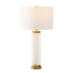 a table lamp with a white shade on the top and gold trimming around it